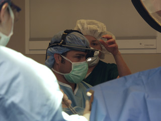 nurse adjusting headlamp during surgery