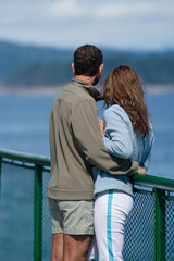 Young couple embracing on a deck of Seattle ferry crossing Puget Sound, WA, USA