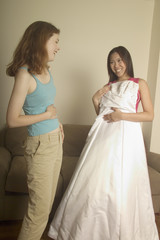 girl shows her friend her wedding dress