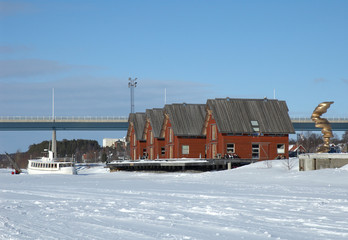 Red houses along the frozen river in Umea, north of Sweden