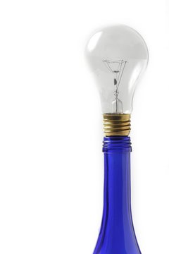 clear light bulb on blue oil bottle