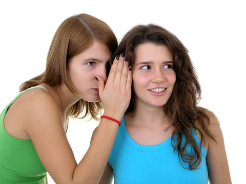 girl whispering in friend`s ear