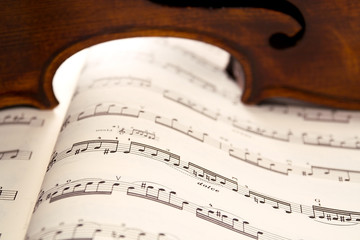 light through violin's ribs on music score