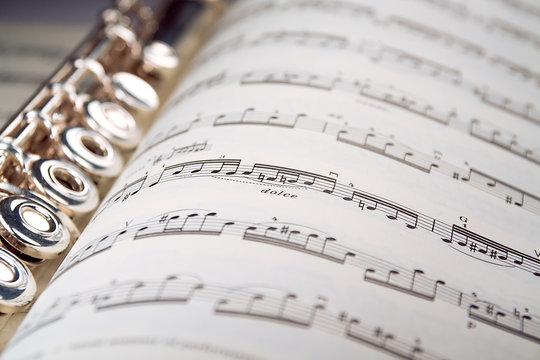 a flute rests inside a musical score