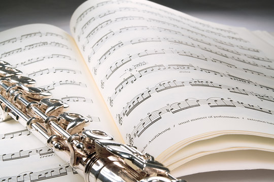 flute on an open musical score with gray background