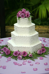 tiered wedding cake with purple flowers
