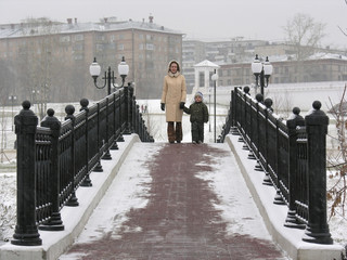 mother with son on winter bridge