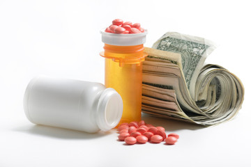 medication beside a roll of money
