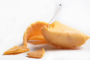cracked fortune cookie with fortune sticking out