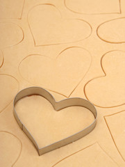 heart cookie cutter on a sheet of cookie dough