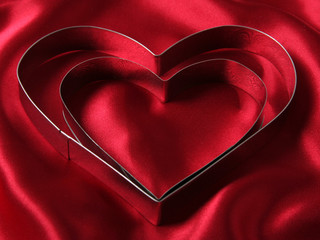 heart shaped cookie cutters on red satin