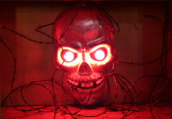 red shining skull behind barbwire
