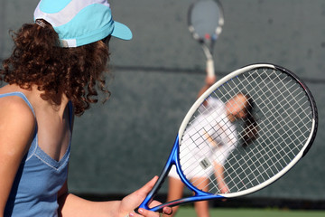 two girls playing tennis