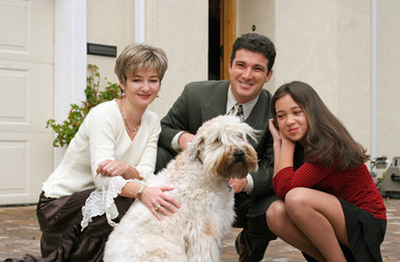 happy family with a dog in front of the home