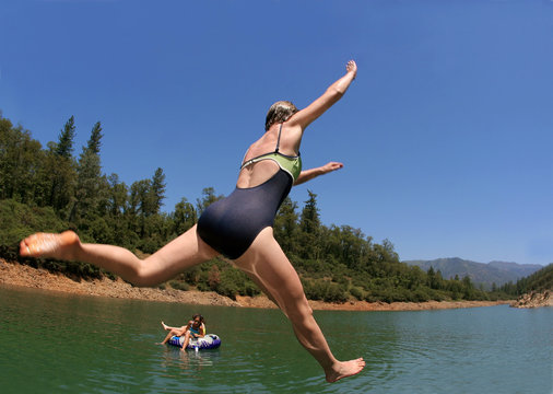 young woman jumping in the lake