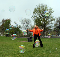 girl playing with bubbles in a park