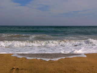 Fototapeta na wymiar symmetrical wave splash on the sand beach