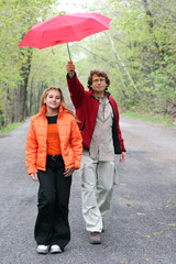 romantic couple walking in a park on a rainy day