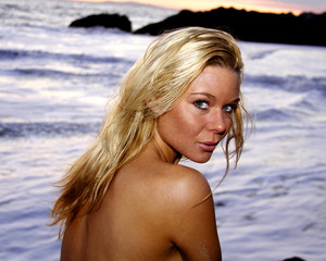 Beautiful woman in a blue bikini on the beach at sunset in Malibu California.