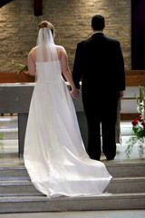 young couple holding hands at altar on wedding day