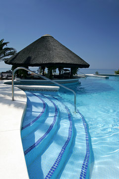 tiki hut and bar by swimming pool of luxury hotel