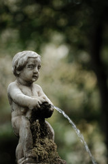 statue of boy with vase pouring water
