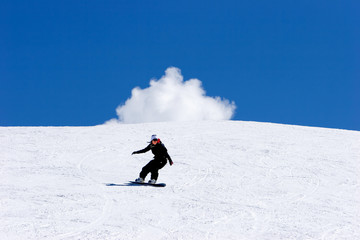 woman snowboarding on slopes of ski resort in spain