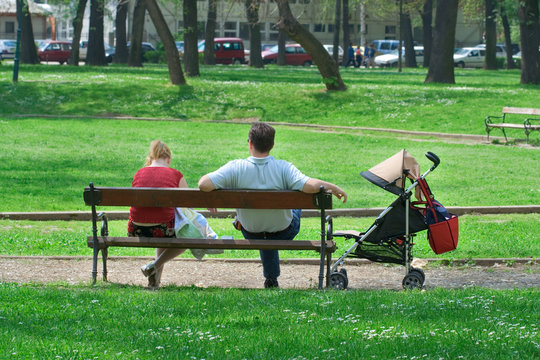 Couple With A Baby Carriage Resting In The Park