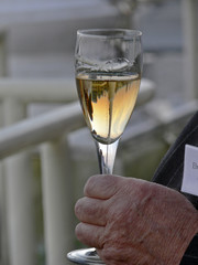 glass of white wine in old man's hand