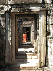 monks walk through passageways at bantaey kdei, an
