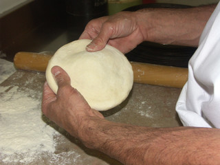 Les mains d'un pizzaïolo faisant sa pâte