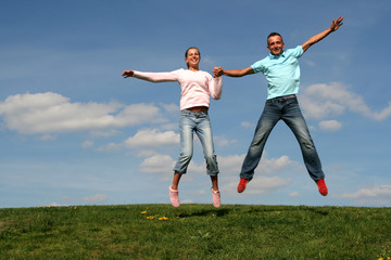 couple jumping against blue sky