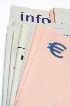 euro symbol on stacked newspapers