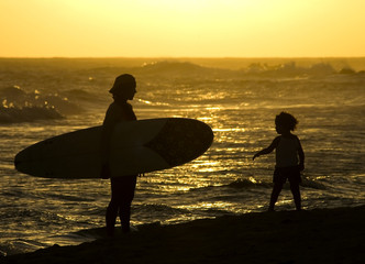 surfer mom and child at sunset