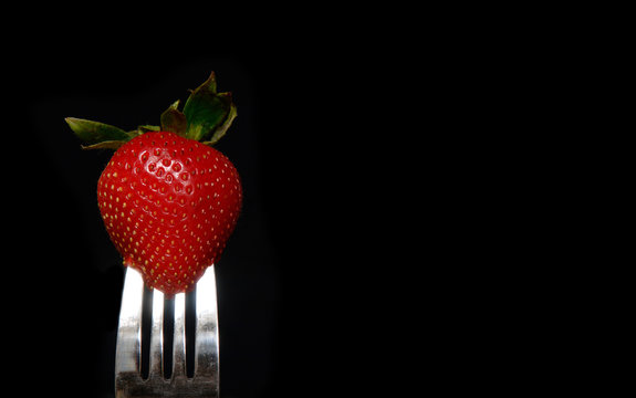 Strawberry On Fork On Black