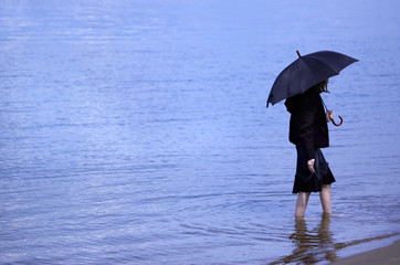 girl with umbrella on the blue water background