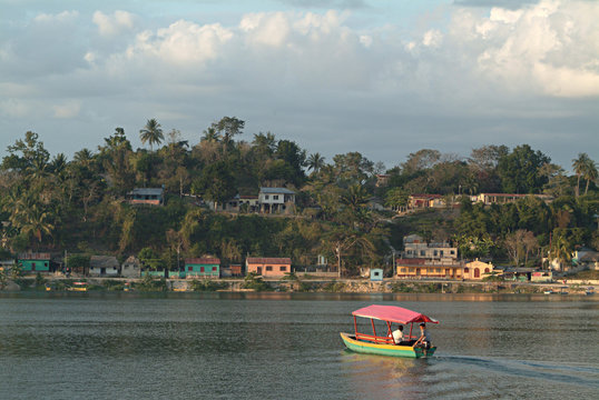small colorful water taxi crosses lake in flores,