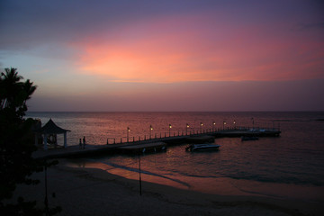 Fototapeta na wymiar people walking on a pier with a beautiful sunset