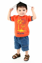 adorable toddler boy with book on head