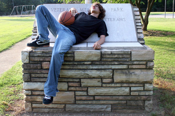 teen boy resting after basketball game