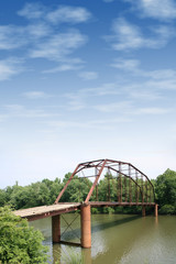 old iron and wooden bridge with large cloudy sky