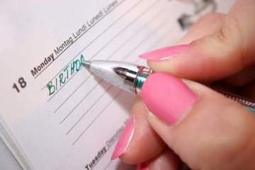 woman holding pen and writing in time schedule