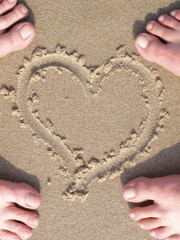 sand heart with lovers foot