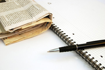newspaper, notebook and pen