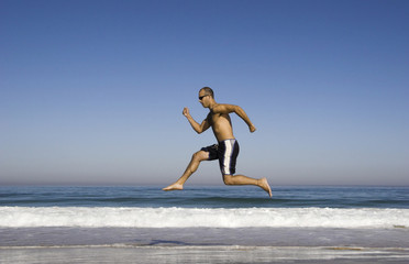 Fototapeta na wymiar man running and jumping on the beach