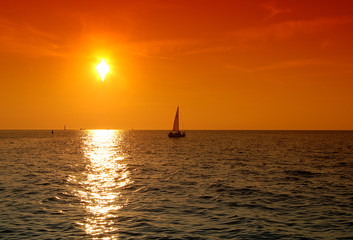 jacht sailing right to the sunset
