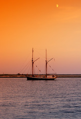 Fototapeta na wymiar ship heading to docks after sunset