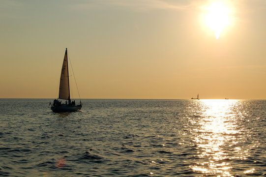 Fototapeta yacht sailing in the sunset
