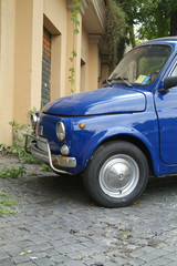 blue italian compact car parked