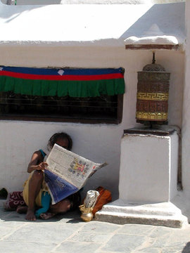 femme lisant le journal & moulin à prière - népal